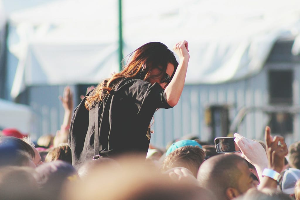woman on top of crowd at one of the free festivals uk
